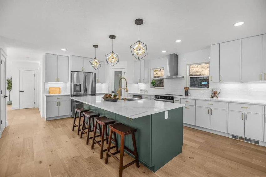 Green kitchen island with white shaker cabinets, quartz countertops, and brass hardware