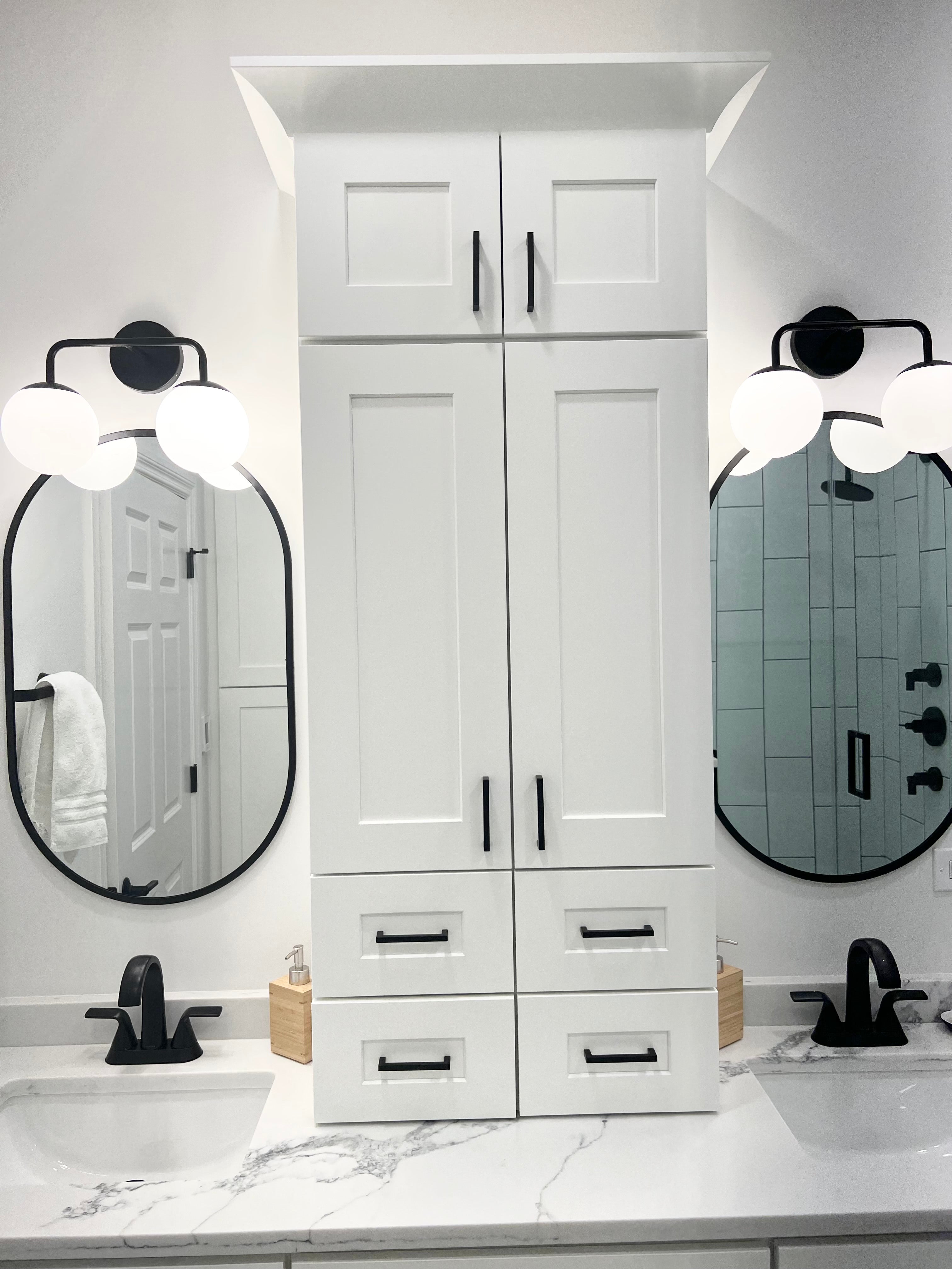 White shaker bathroom vanity with integrated linen cabinet, matte black faucets and cabinet hardware, quartz countertop, and modern wall sconces