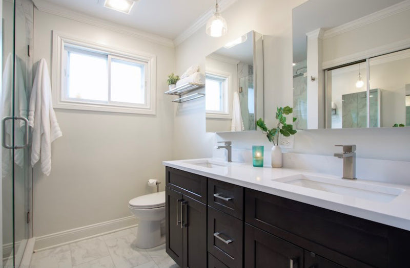 Bathroom with dark espresso shaker double vanity, white quartz countertop, brushed nickel faucets and hardware, marble tile floor, and glass shower enclosure