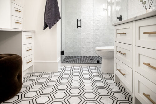 Black and white hexagon mosaic bathroom floor tile with white shaker vanity and gold hardware