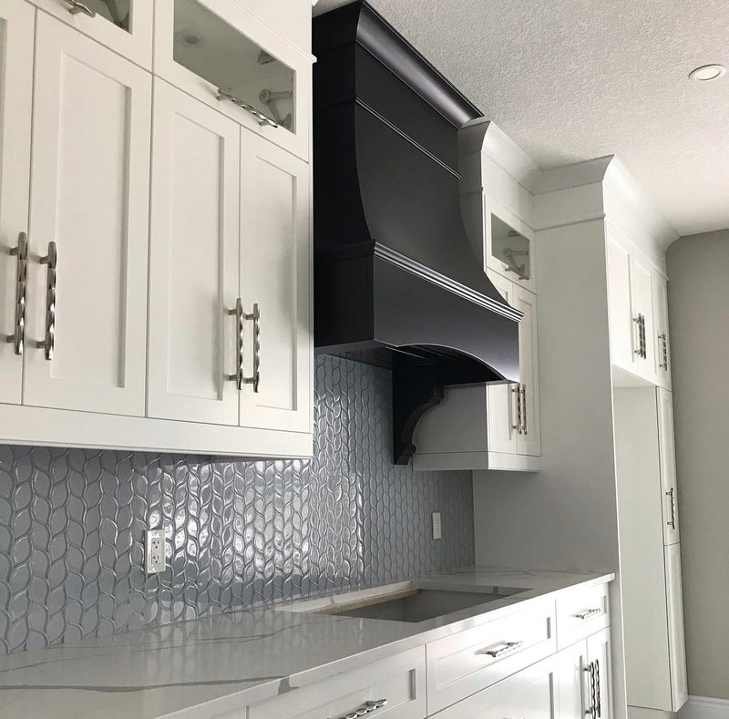 White shaker kitchen with Rose Hill cabinets, black custom range hood, textured tile backsplash, and polished quartz countertops.