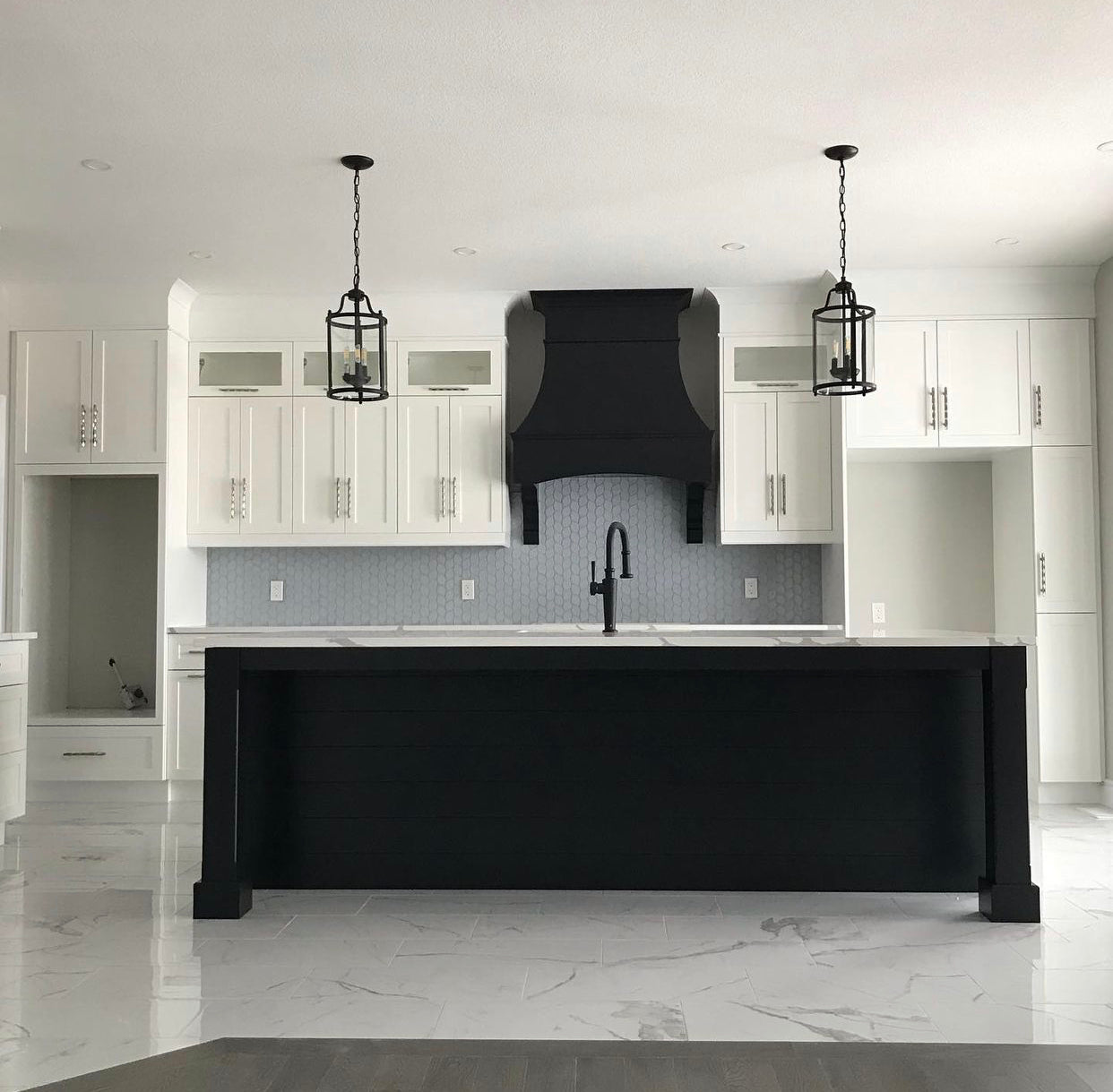 Rose Hill Cabinets kitchen with custom black wood hood, quartz countertops, MSI tile backsplash, and clean white cabinetry showcasing a timeless, professionally designed kitchen layout