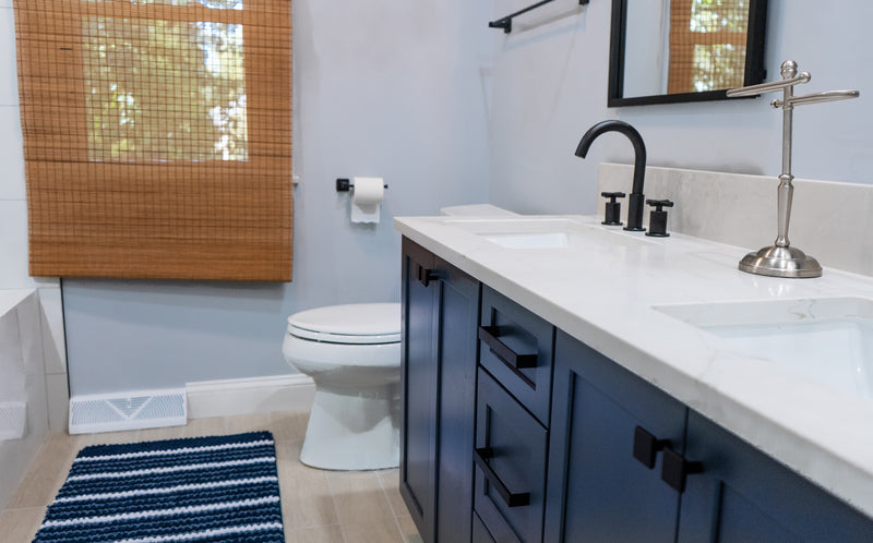 Navy shaker vanity with double undermount sinks, white quartz countertop, and matte black faucet and hardware