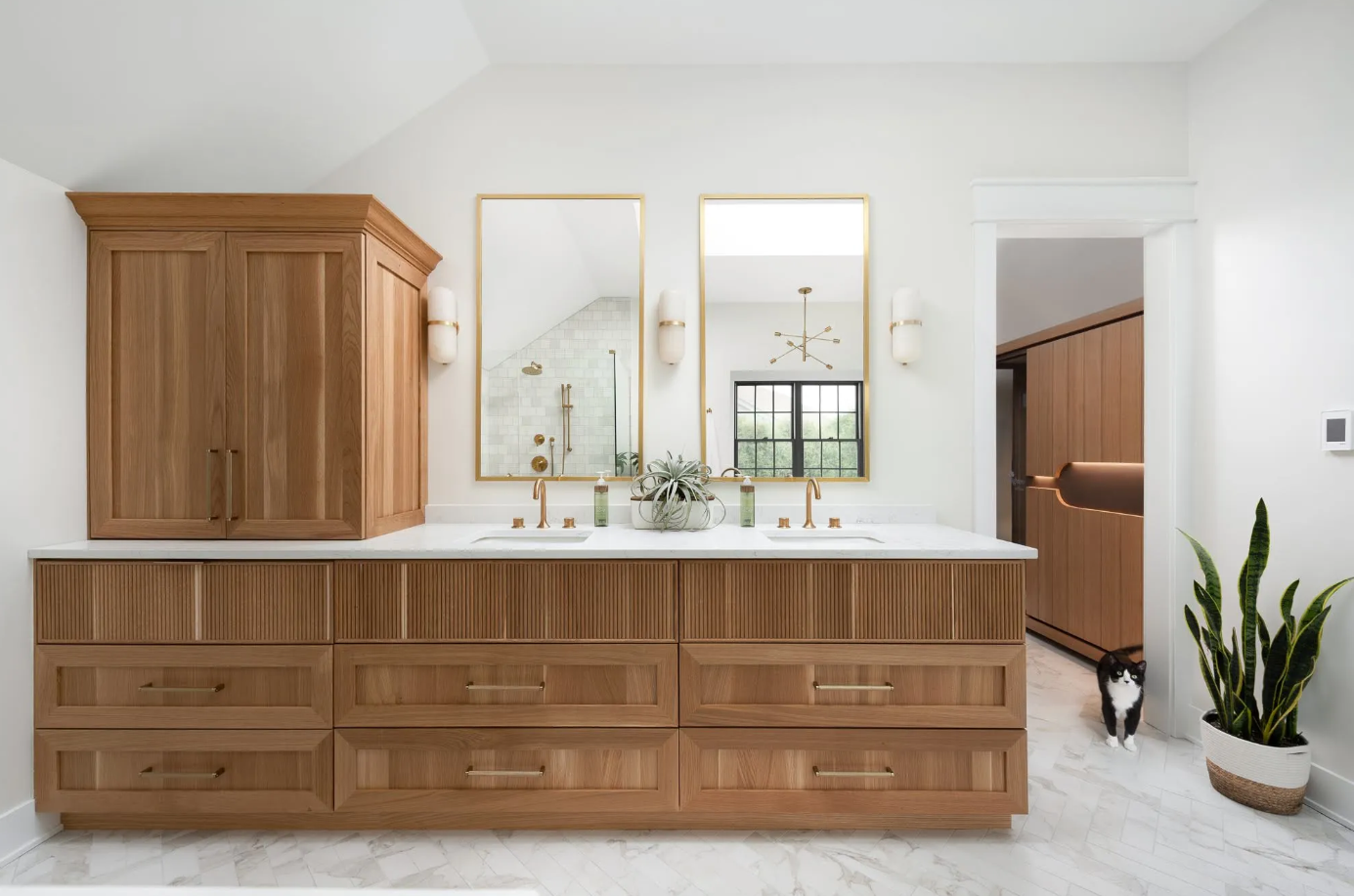 Bathroom with custom wooden vanity, mirrors, and brass fixtures