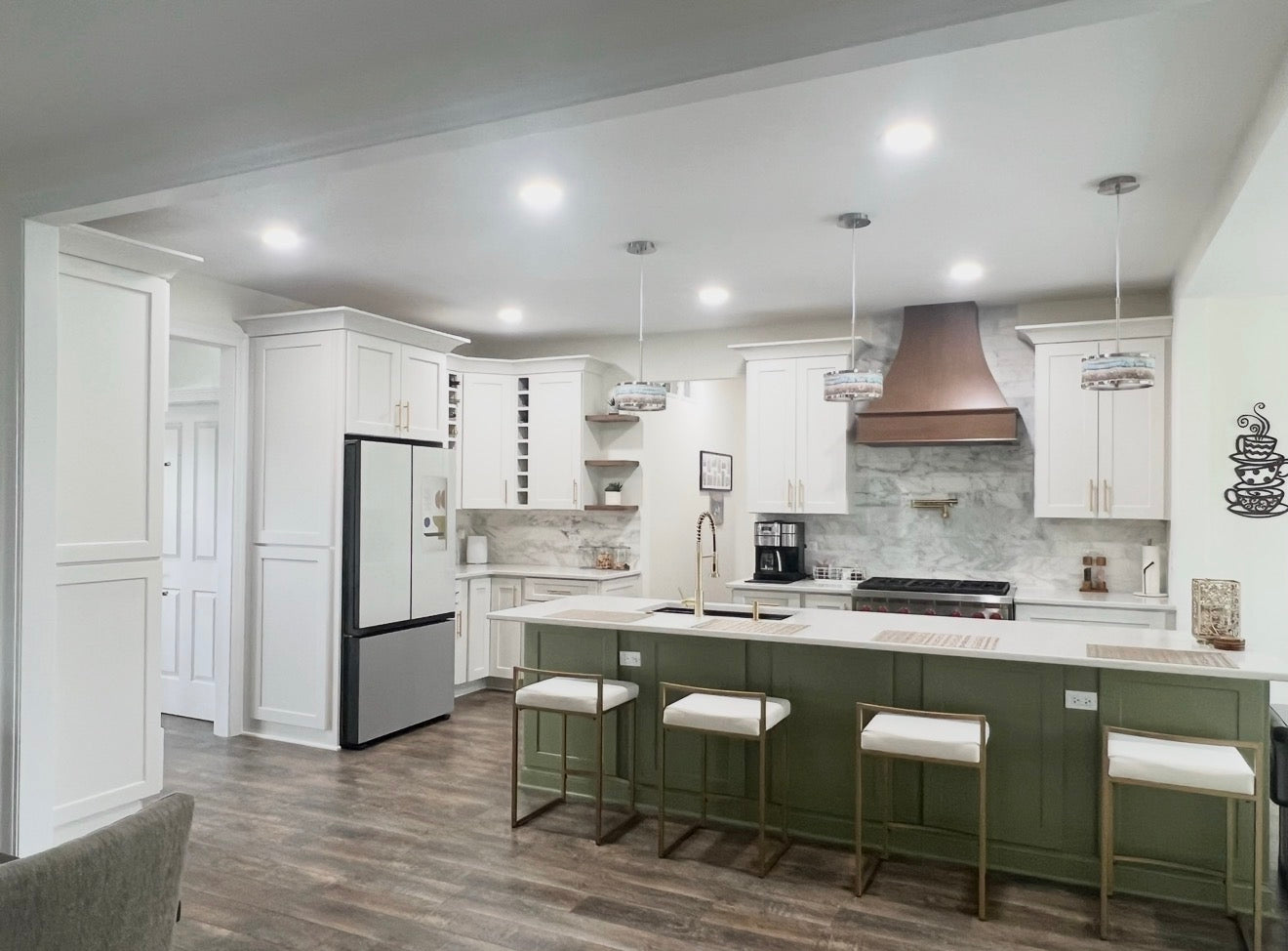 A kitchen featuring a Wolf island, Legend wall and base cabinets, a custom Woodland hood, and engineered hardwood flooring.