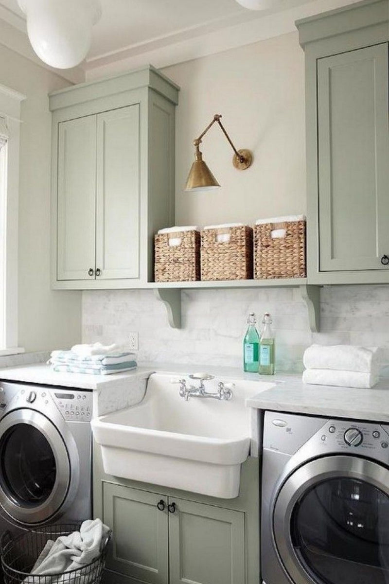 Modern laundry room with sage green cabinets, white farmhouse sink, subway tile backsplash and storage solutions - home organization from Emerald Fern Finishes