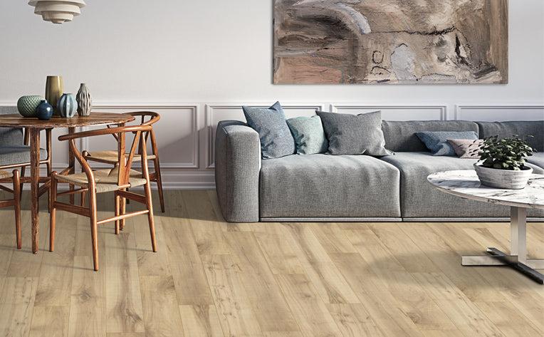 Modern living room with light natural wood luxury vinyl plank flooring, gray sofa, and wainscoting