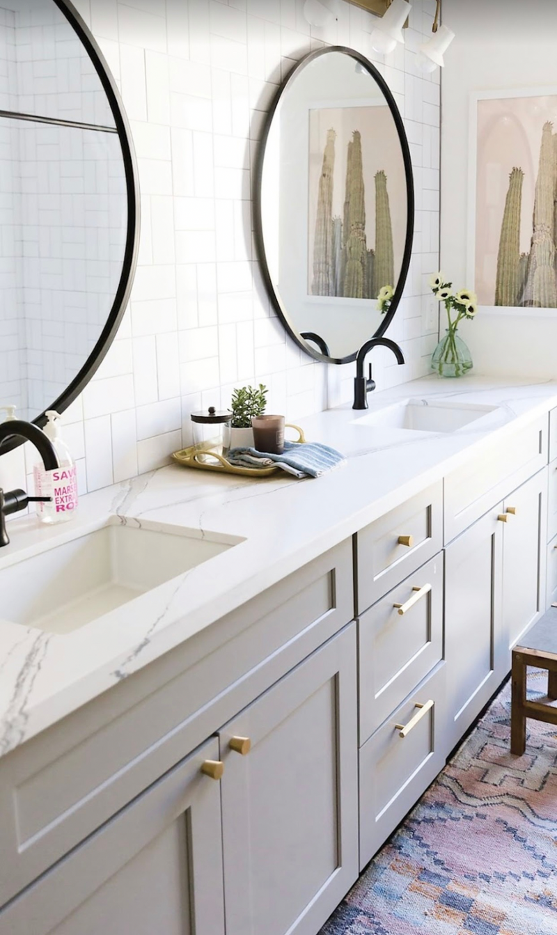 Rose Hill Cabinets gray shaker double vanity with marble quartz countertop, gold hardware, matte black faucets, and round black mirrors