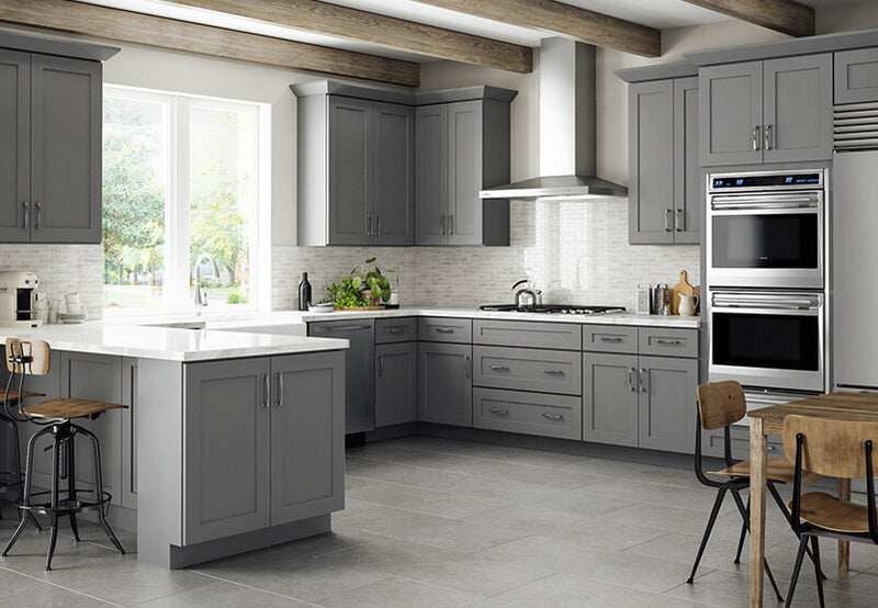 Gray shaker kitchen cabinets with brushed nickel bar pulls, quartz countertops, subway tile backsplash, and stainless steel appliances