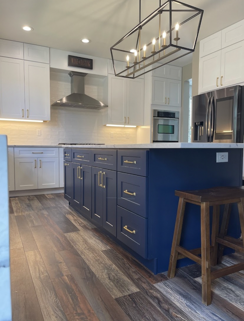 1:55 PM
Rose Hill Cabinets navy blue and white shaker kitchen with gold hardware, marble quartz countertop, white subway tile backsplash, under-cabinet lighting, and black and gold lantern pendant