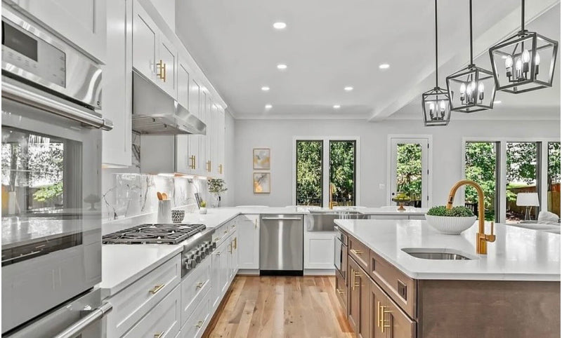 1:26 PM
Bright kitchen with white shaker cabinets, warm wood island, white quartz countertop, marble slab backsplash, gold hardware and faucet, black lantern pendants, and light hardwood floors
