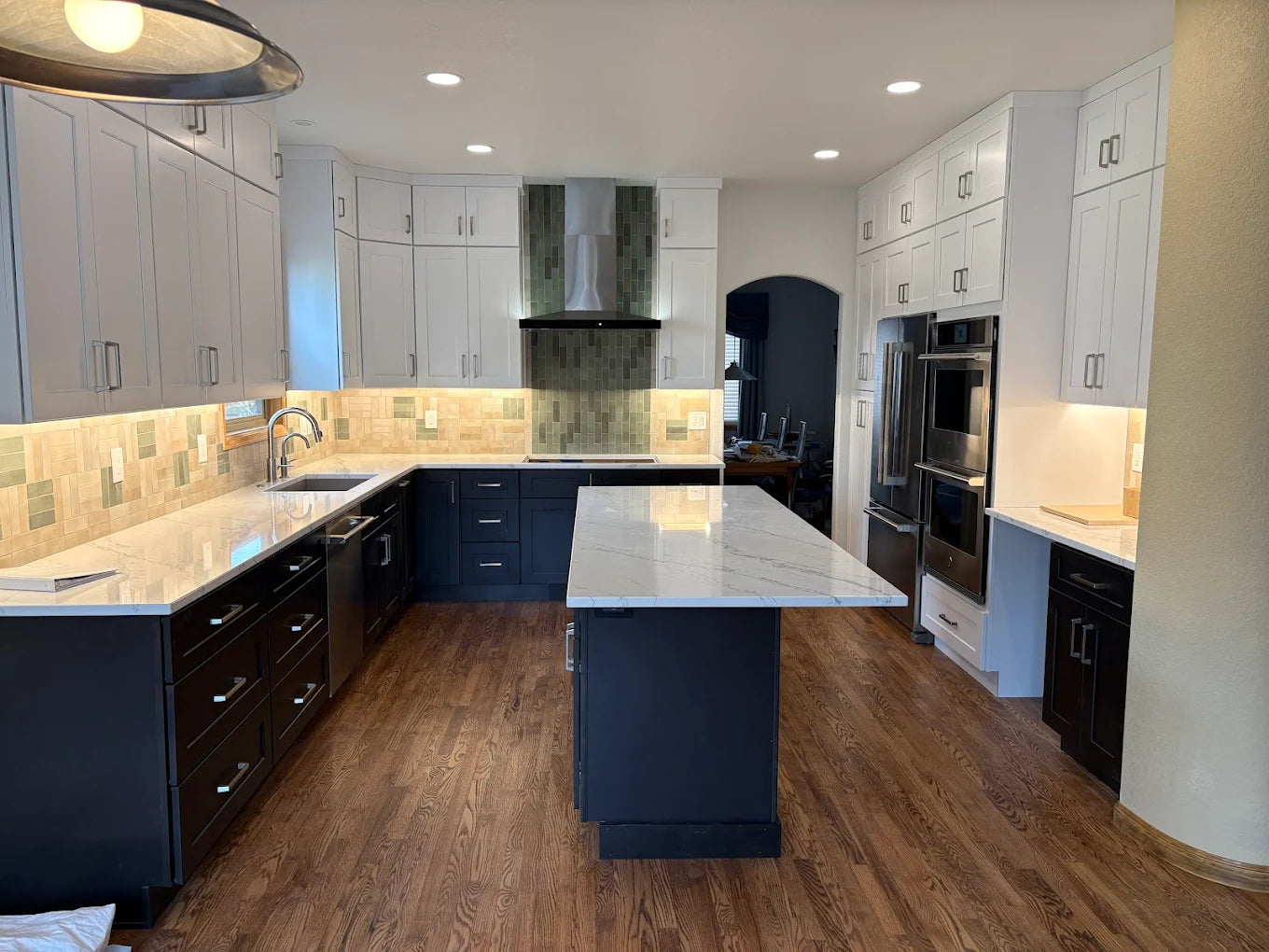 Luxury vinyl plank flooring, white and navy shaker cabinets Rose Hill Cabinets curated by Emerald Fern Finishes, designed for everyday durability with the look of natural wood.